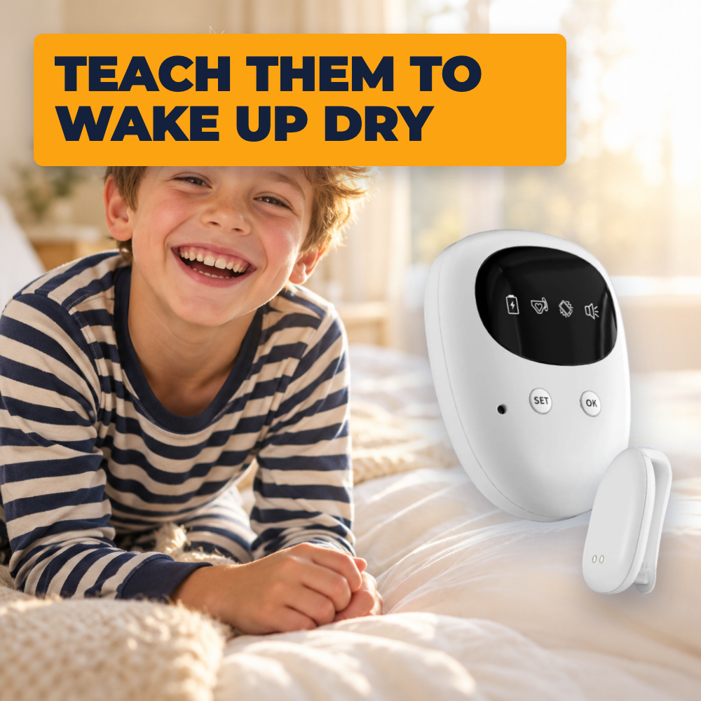 A smiling boy in striped pajamas lying on his bed, with the alarm and sensor beside him. Teach them to wake up dry.